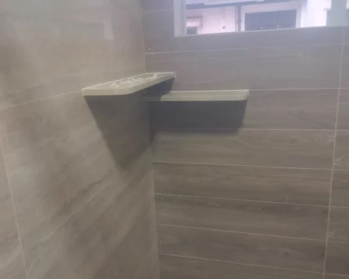 Two wall-mounted bathroom floating shelves installed in a tiled corner.